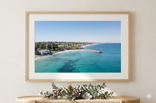 Framed photograph of a coastal scene with a clear blue sky and turquoise water.