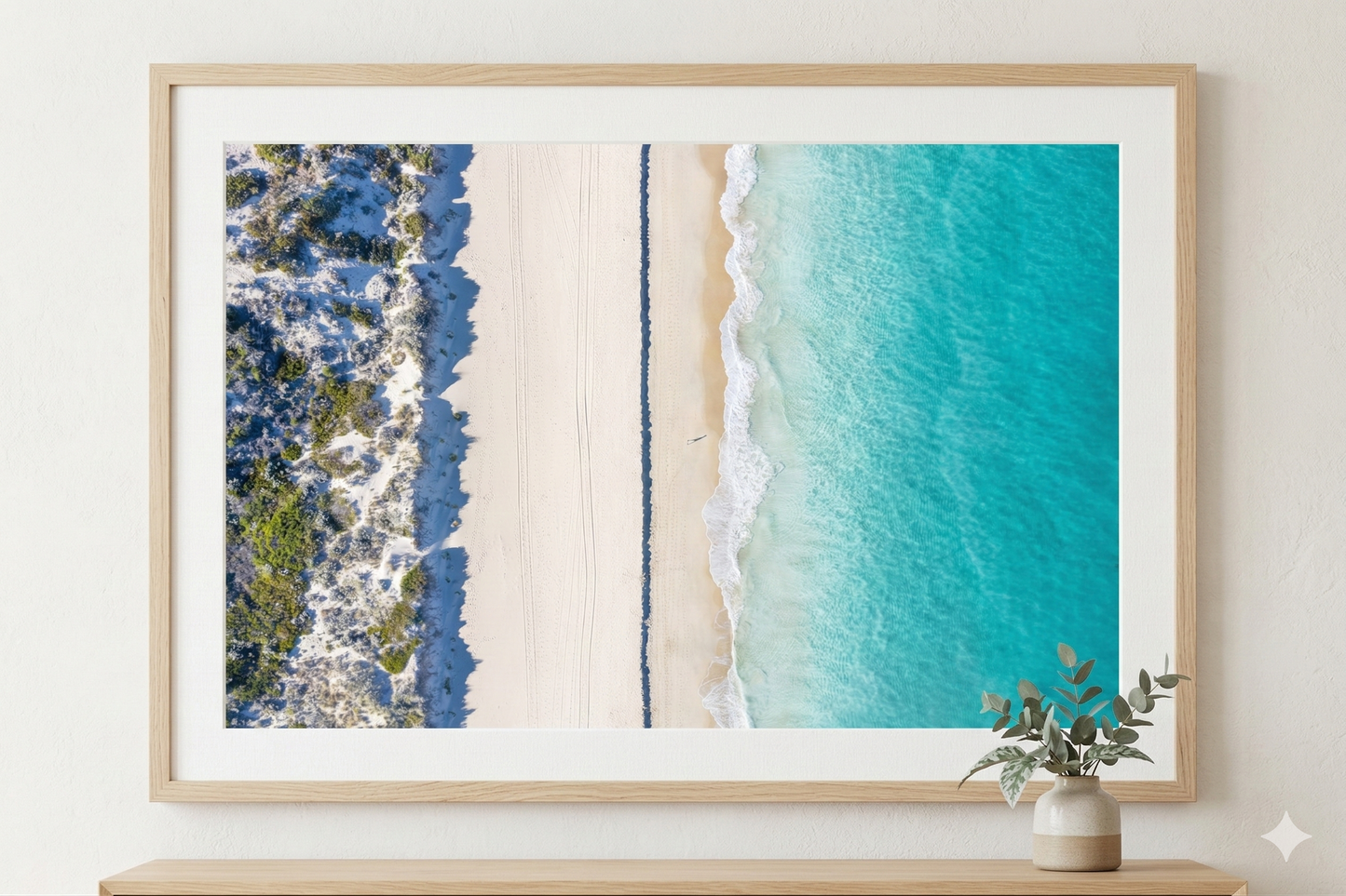 Framed artwork of a beach scene with turquoise water and blue sky.
