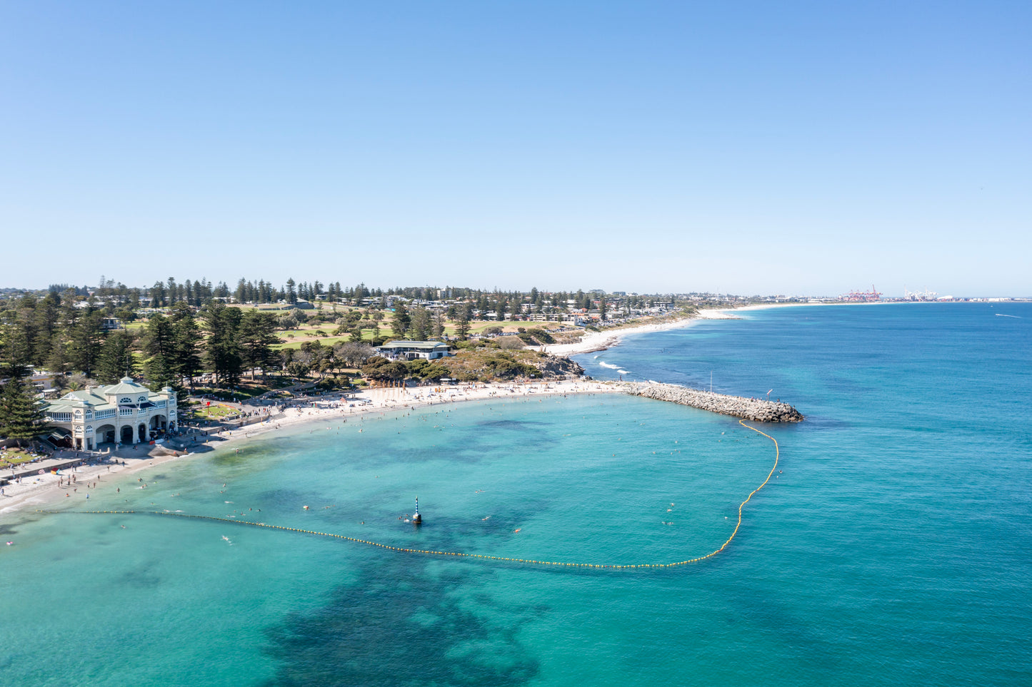 Aerial view of a coastal area with clear blue water and a beach.