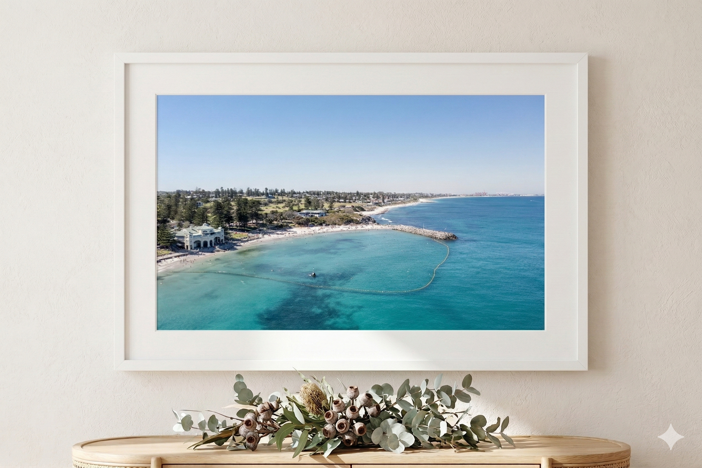 Framed photograph of a coastal scene with clear blue water and a white frame.