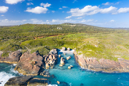 Scenic view of a coastal landscape with rocky outcrops and clear blue water.