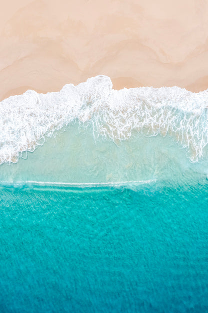 Close-up of ocean waves meeting a sandy beach