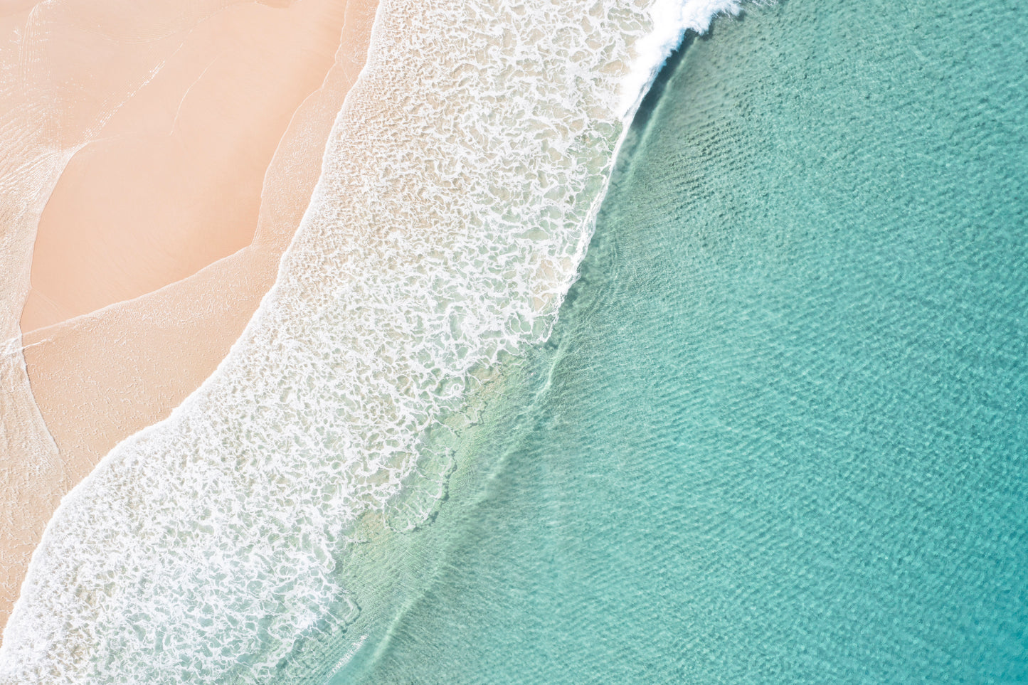 Close-up of a wave crashing onto a sandy beach