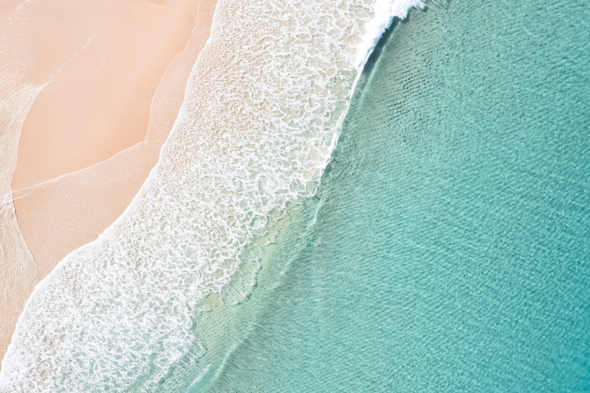 Close-up of a wave crashing onto a sandy beach