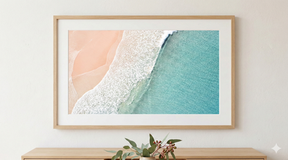 Framed artwork with abstract design of pink, white, and blue on a wall.