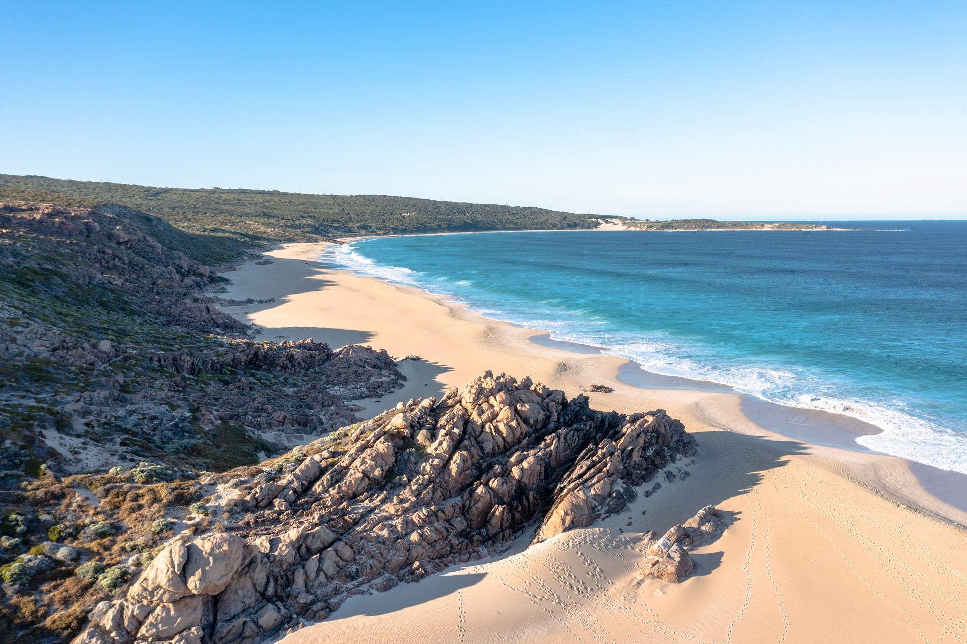 Beach scene with rocky outcrops and clear blue water