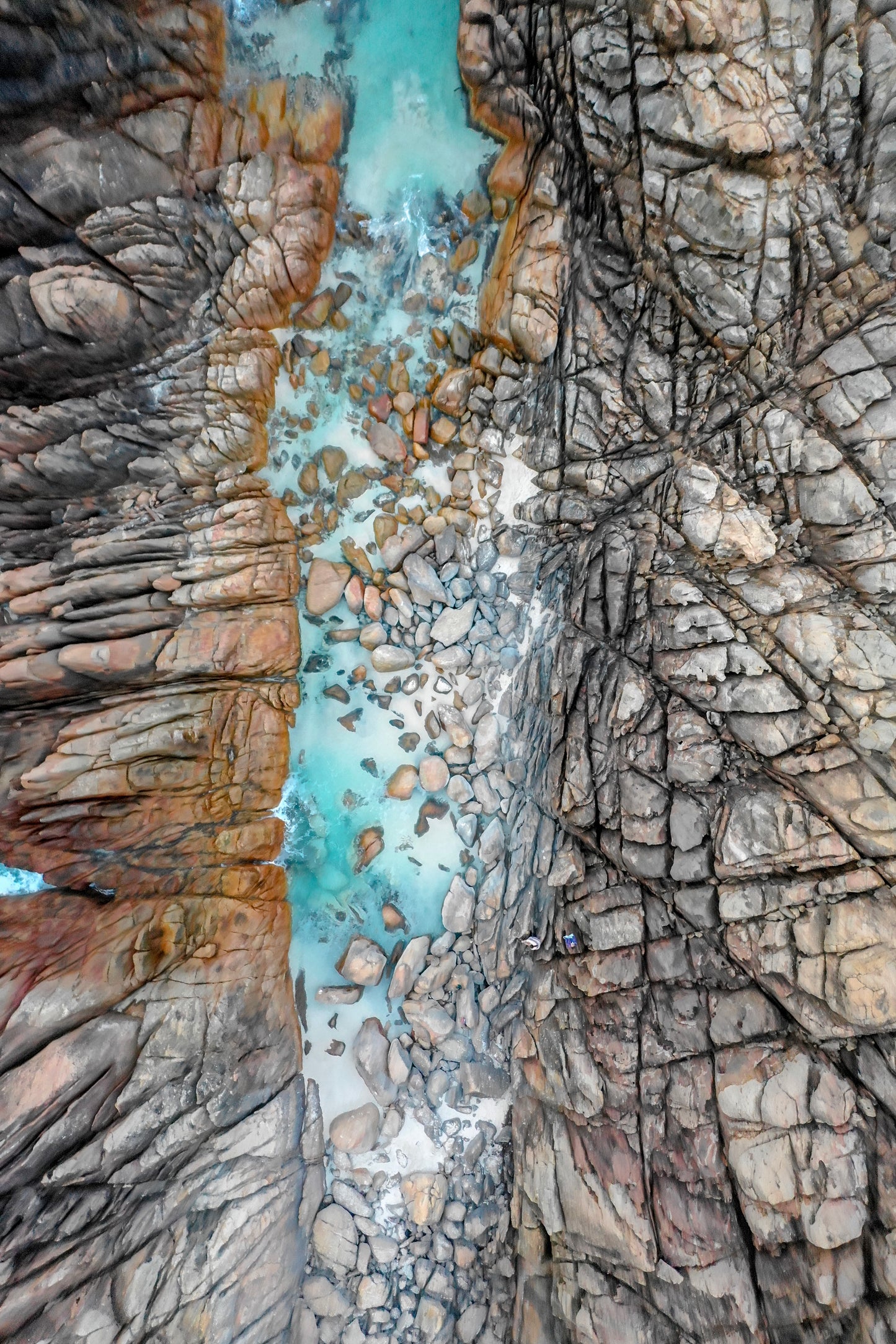 Close-up of rugged rock formations with a small stream flowing between them.