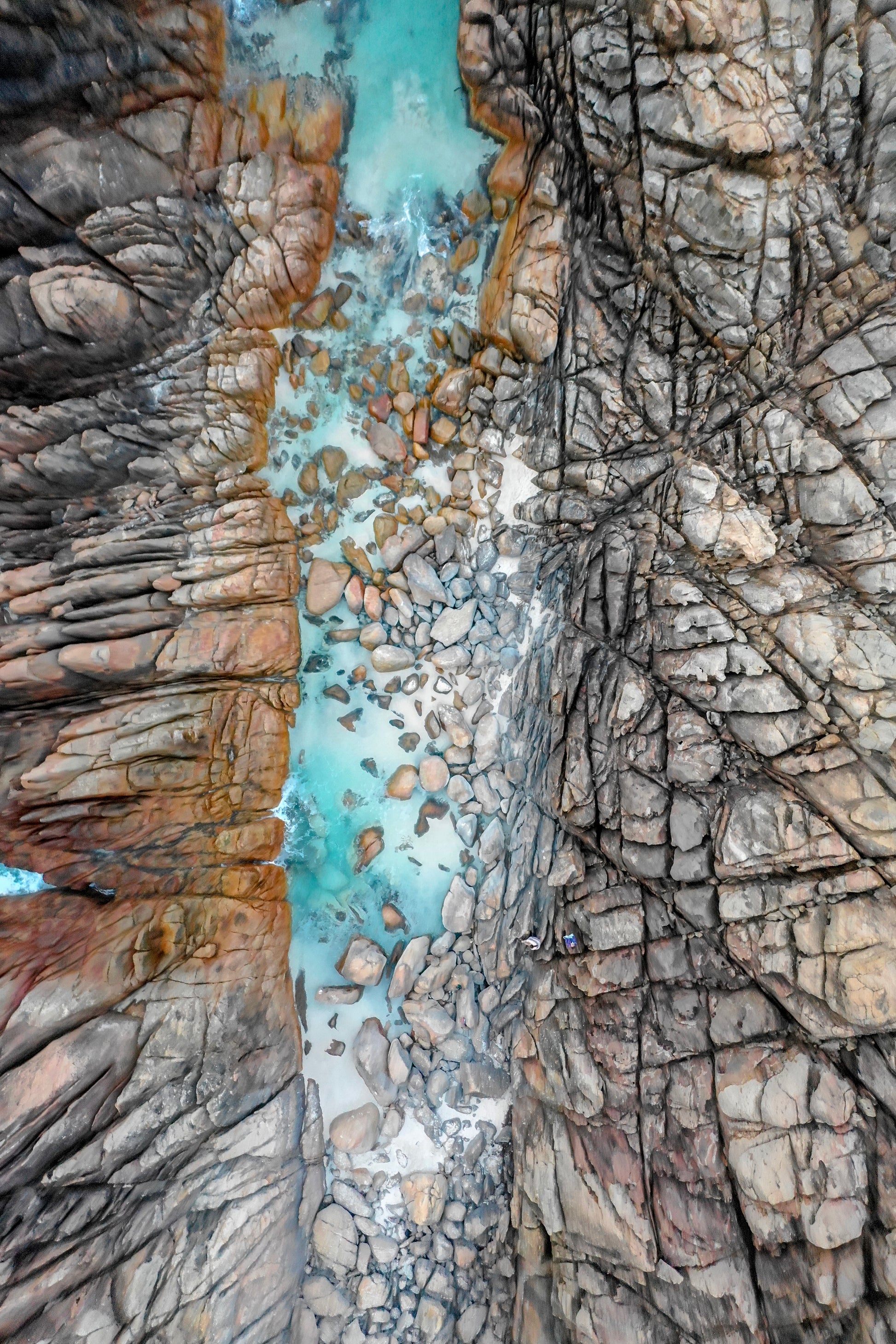 Close-up of rugged rock formations with a small stream flowing between them.