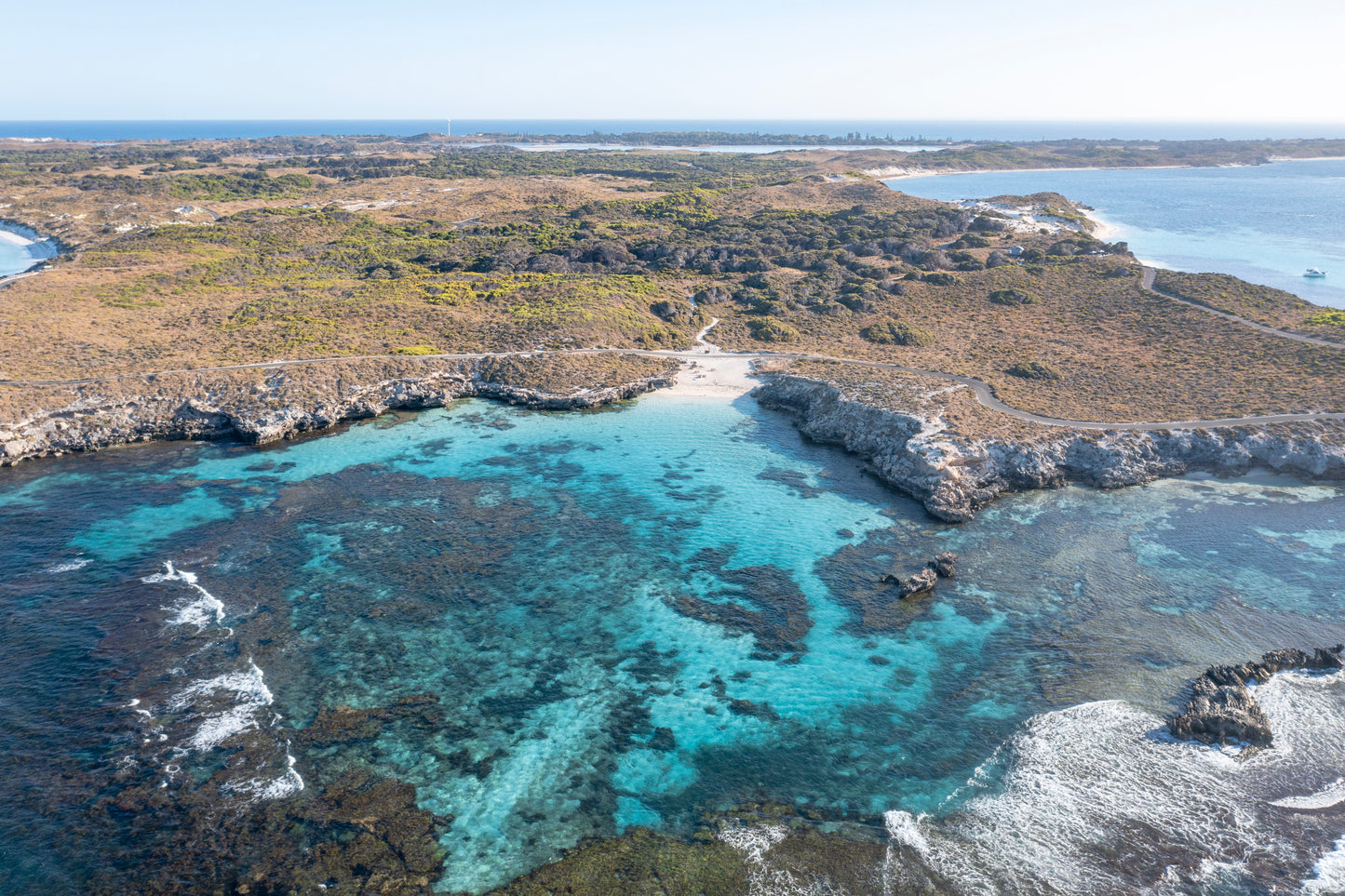 Coastal landscape with clear blue water and rocky shoreline