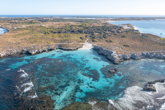Coastal landscape with clear blue water and rocky shoreline