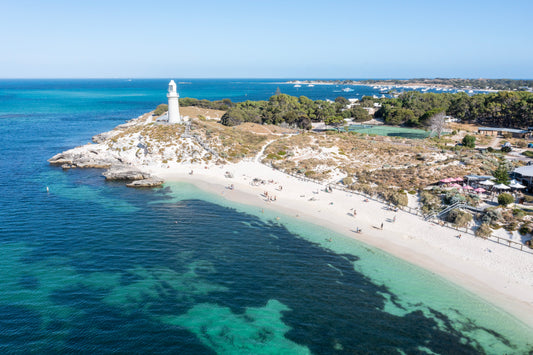 Beach scene with a lighthouse and clear blue water