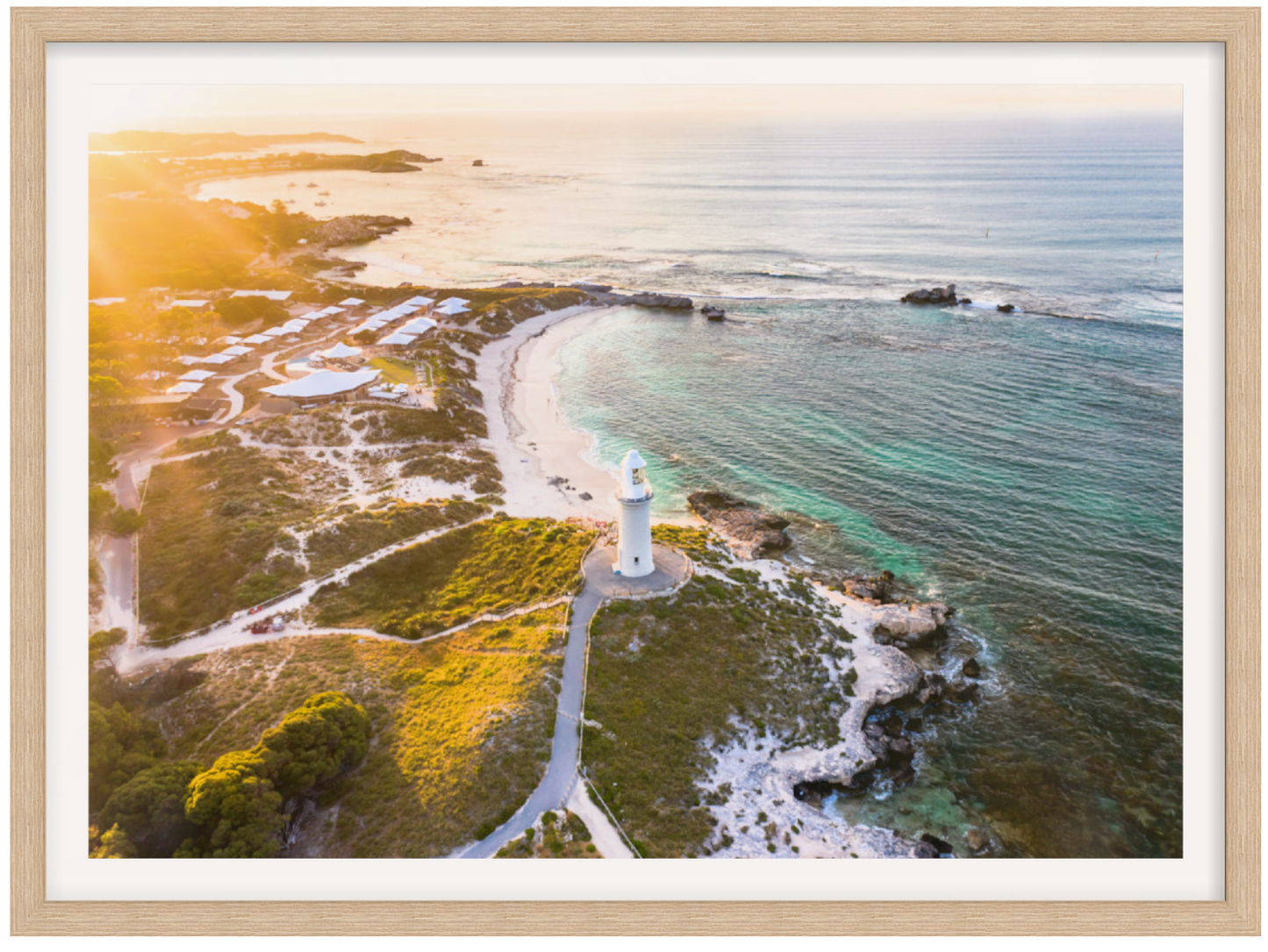Lighthouse on a coastal island with a scenic view of the ocean and sky.