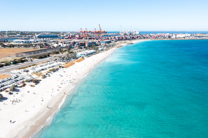 Aerial view of a coastal area with a beach and shipping containers.