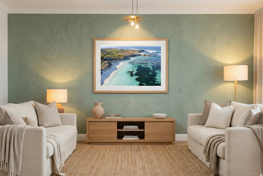 Living room with beige sofas, a wooden coffee table, and a framed picture of a beach on the wall.