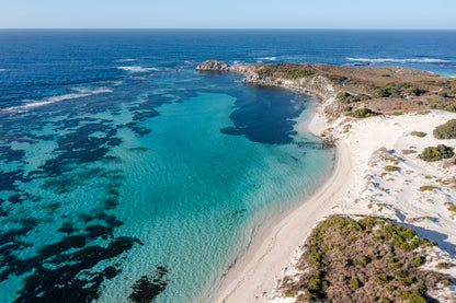 Aerial view of a beach with clear blue water and a small island.