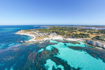 Aerial view of a coastal area with turquoise waters and a clear blue sky.