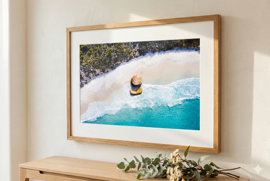 Framed photograph of a person in a hot tub with a natural landscape, displayed on a wall.