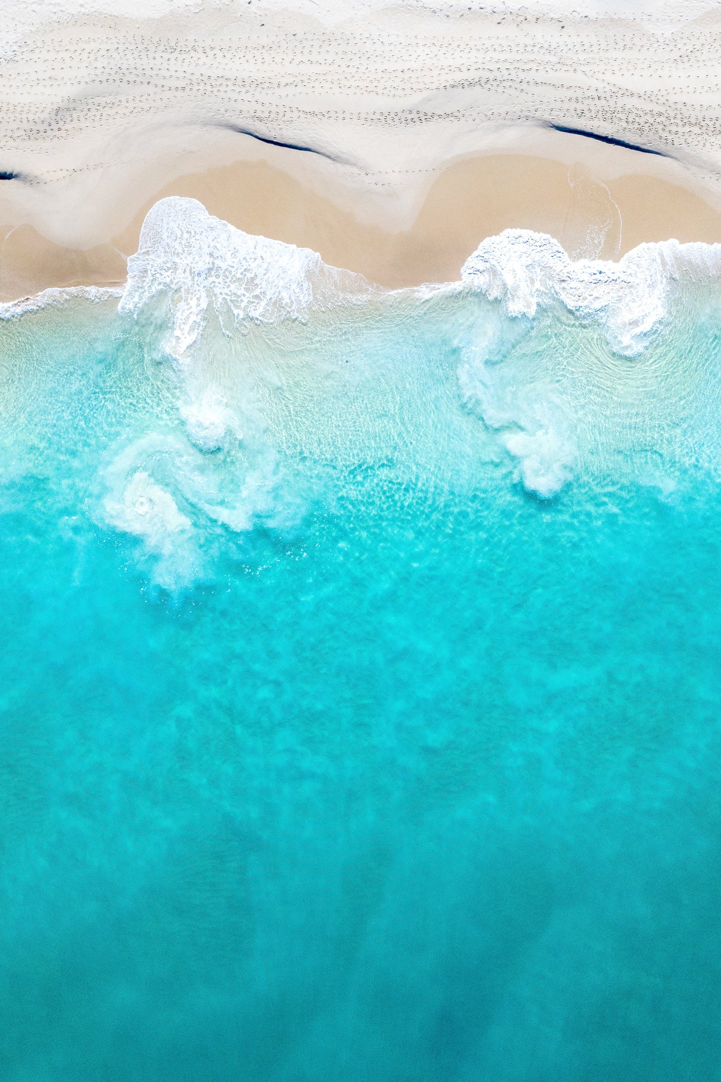 A fine art print featuring a beach scene with ocean waves and sand.