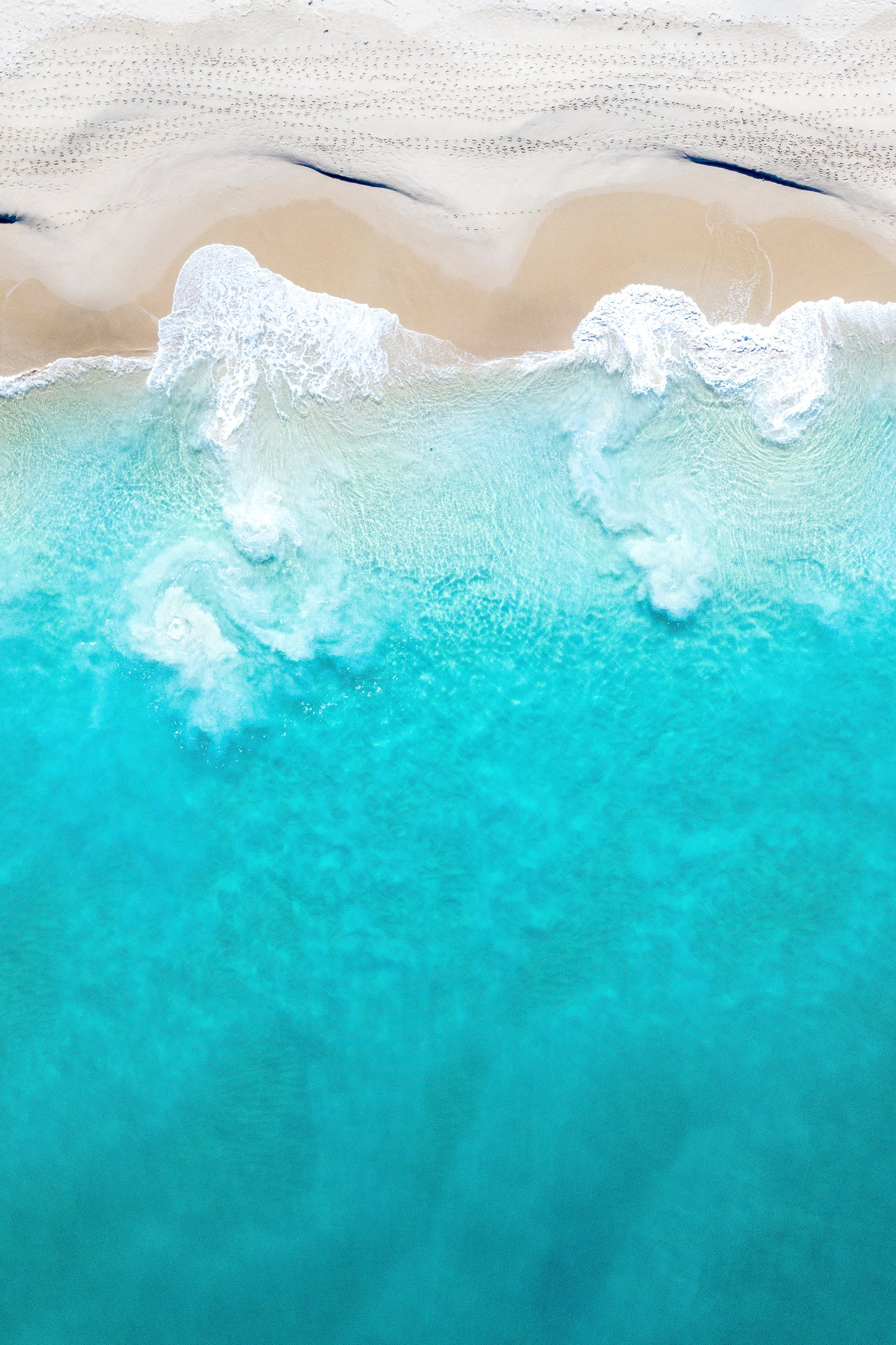 A fine art print featuring a beach scene with ocean waves and sand.