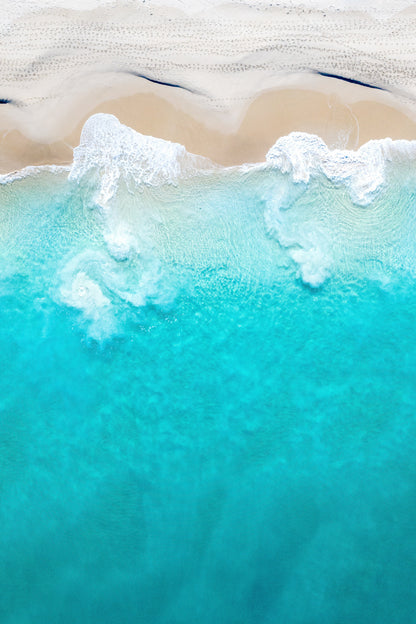 A fine art print featuring a beach scene with ocean waves and sand.