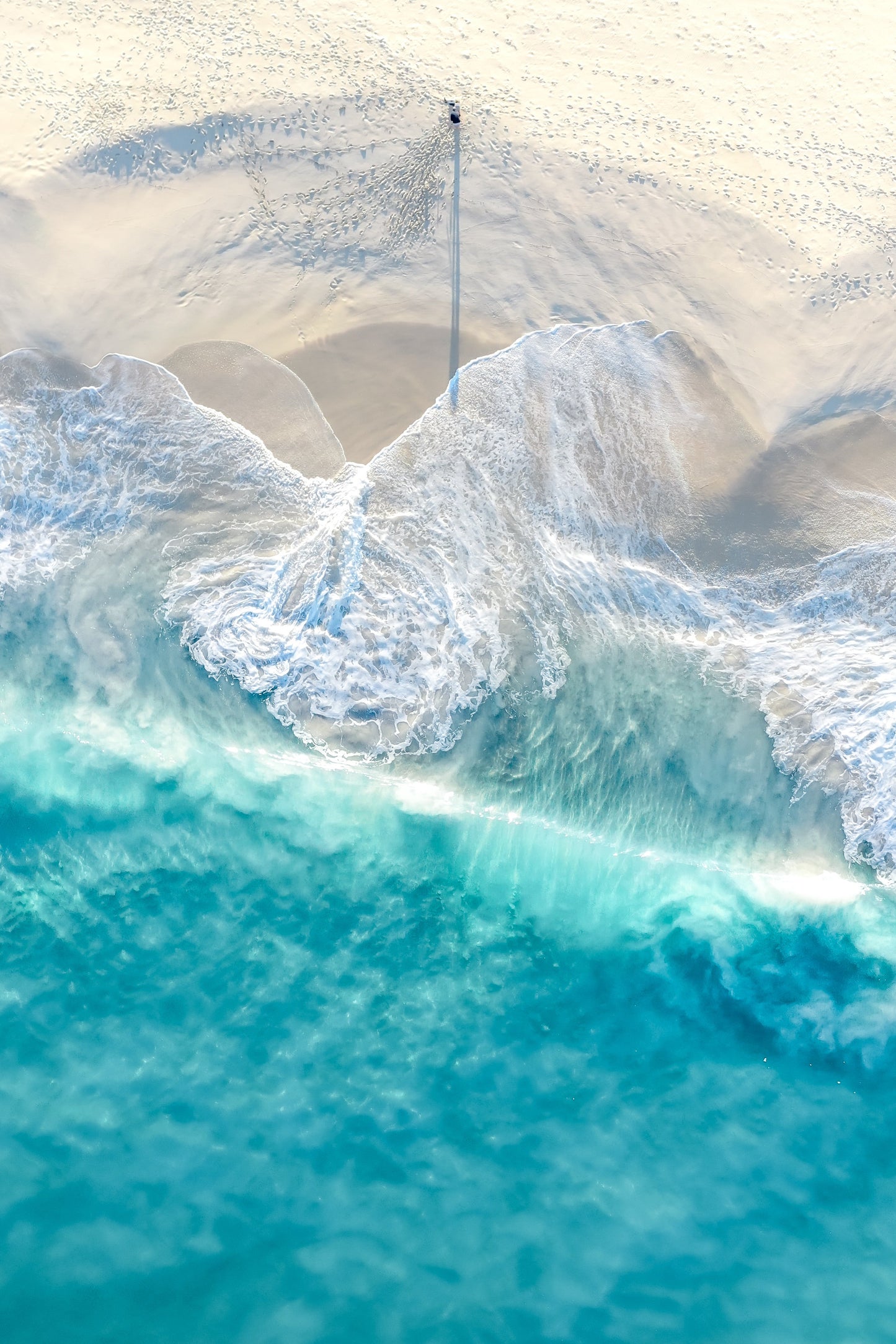 A fine art print featuring a beach scene with a large body of water and a small part of the beach showing foam and sand.
