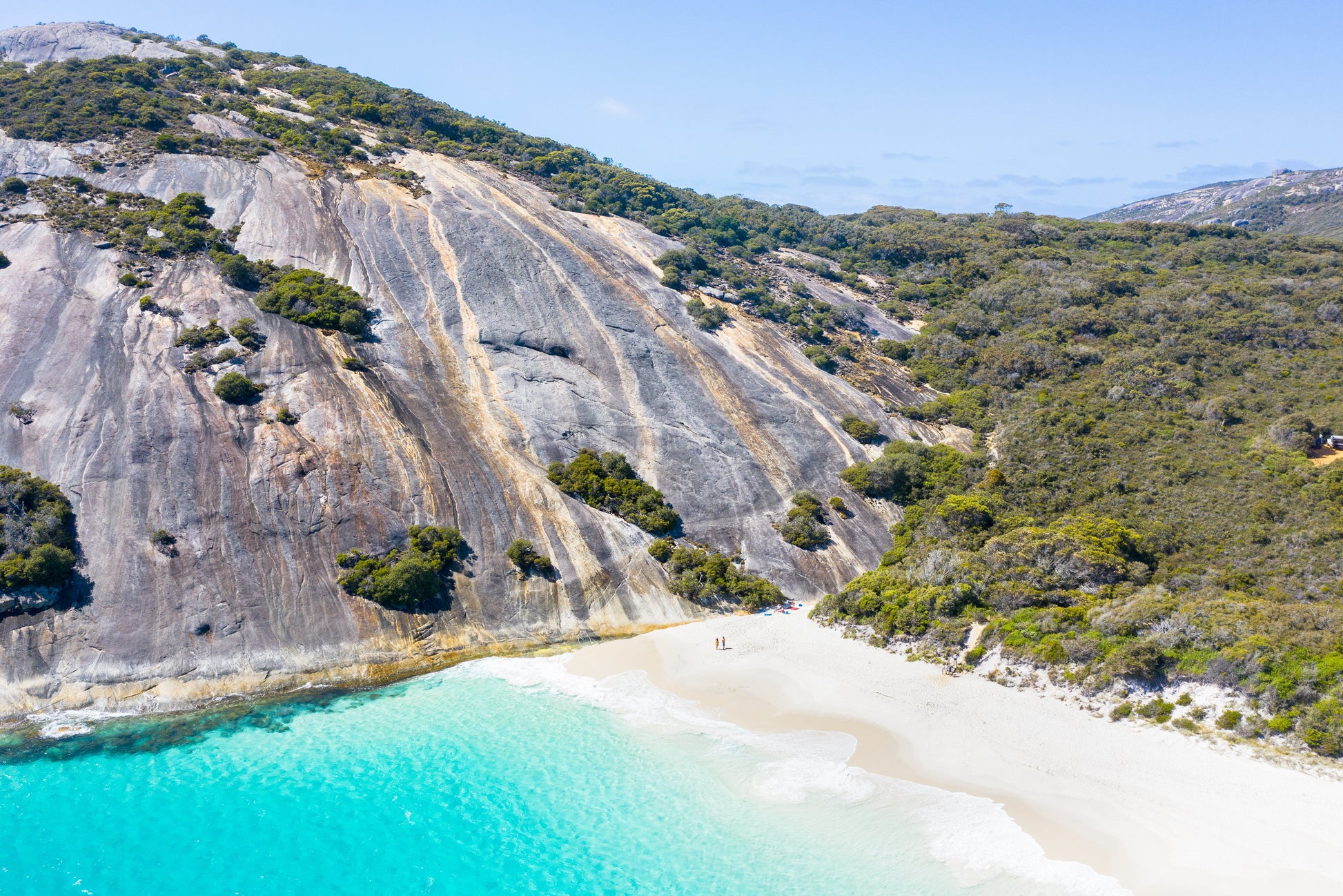 Beach with turquoise water and a rocky hillside